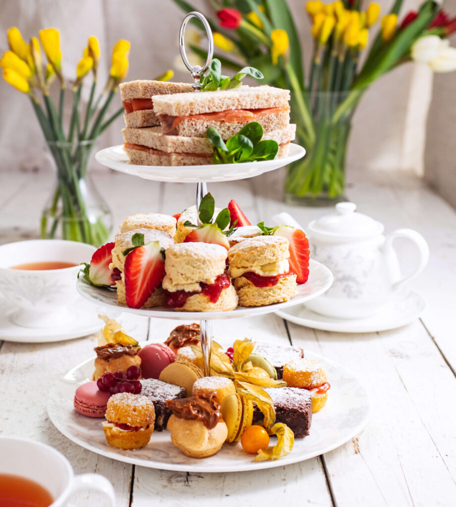 3 tier stand of cakes and sandwiches